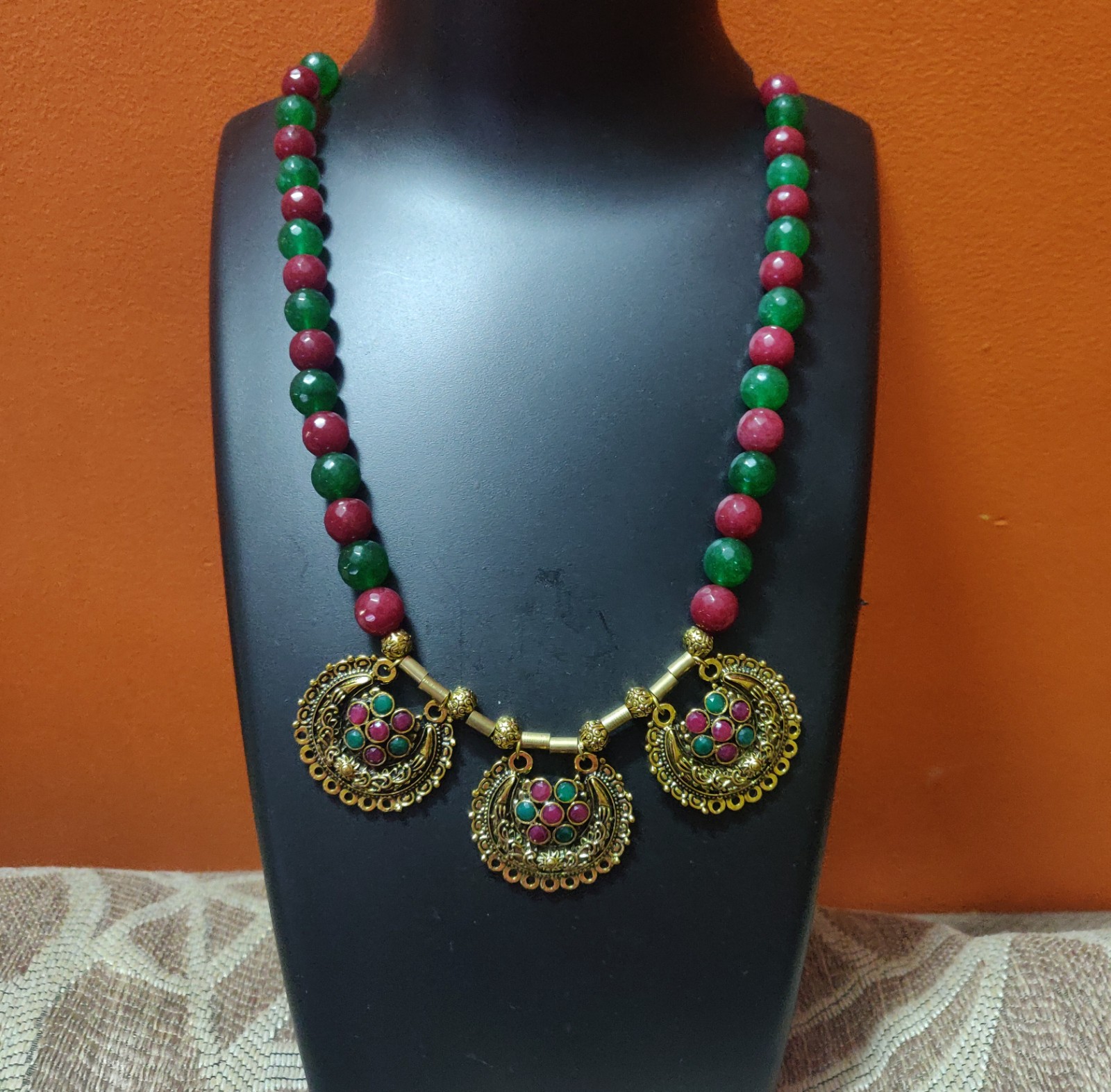 Red and green Semi precious beads necklace with stone studded pendants.