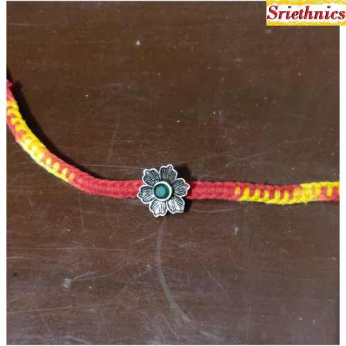 Silver flower with green stone rakhi