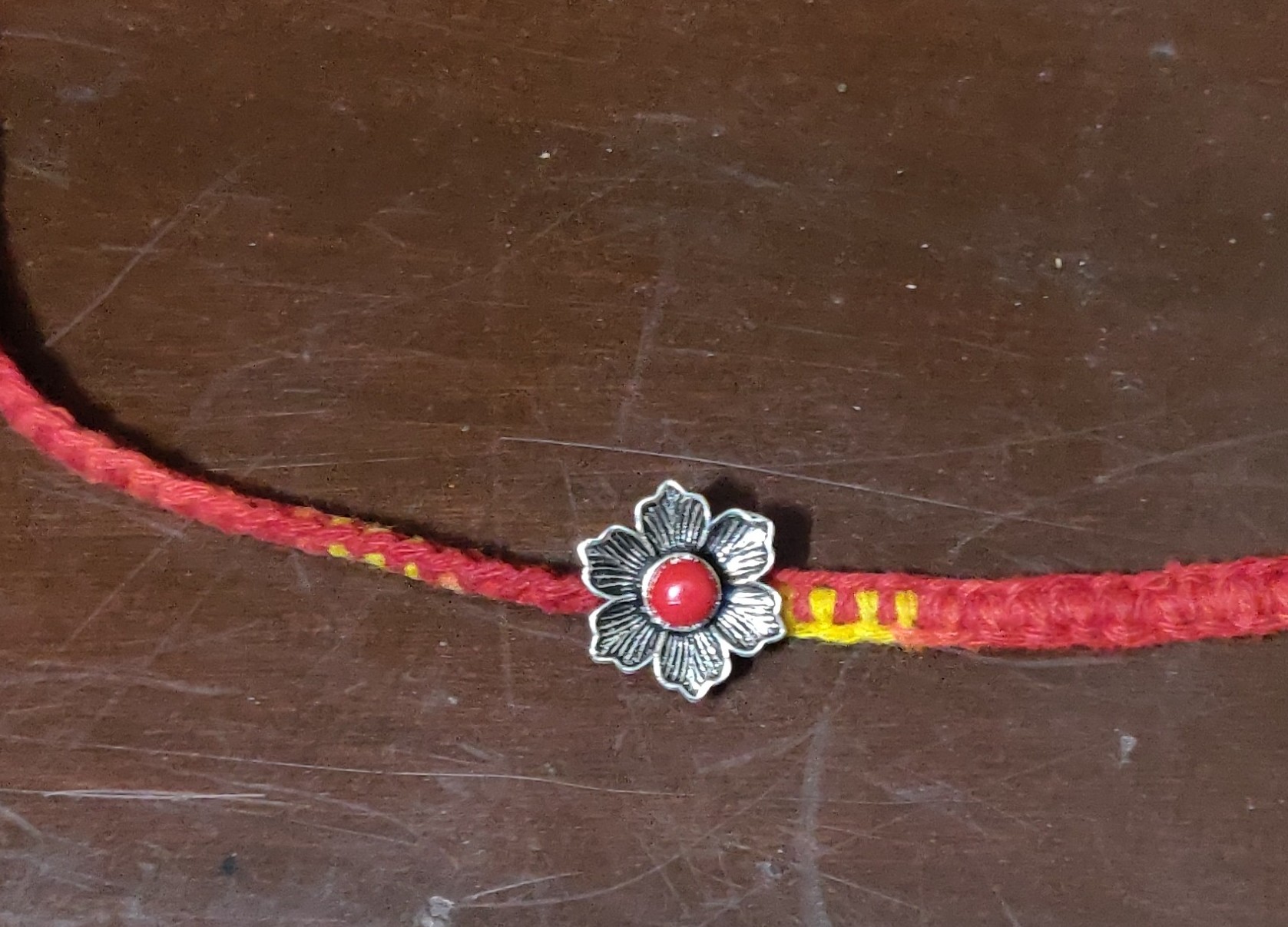 Silver flower with coral rakhi