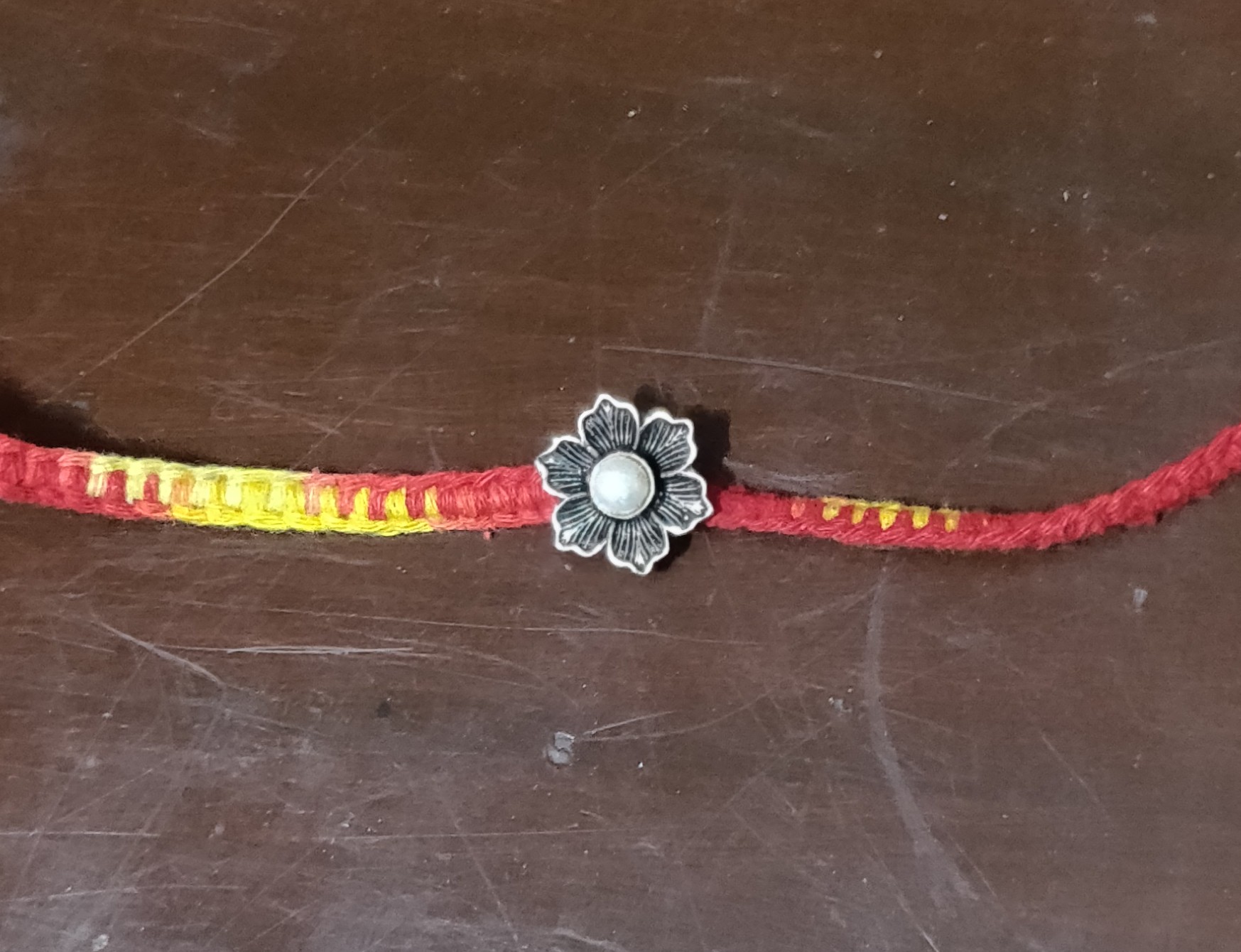 Silver flower with pearl rakhi