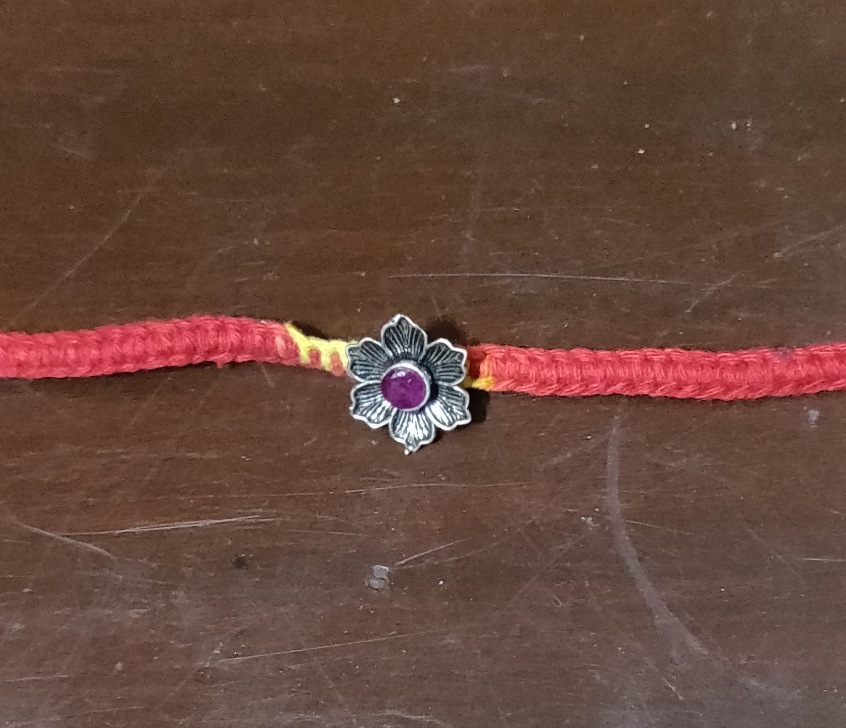 Silver flower with pink stone rakhi